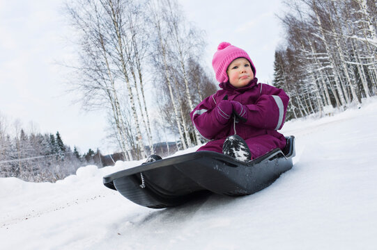 Little Girl on Sled in Winter
