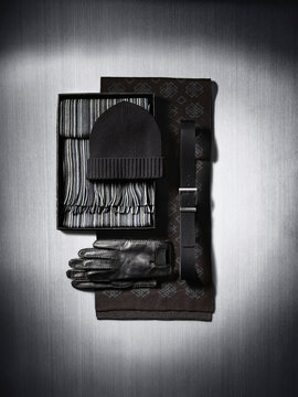 Scarves, gloves, cap and belt on metallic background in studio