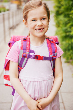5 Year Old Schoolgirl with Pink School Bag Smiling with Missing Teeth