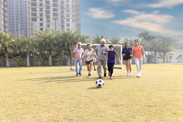 Fototapeta premium Happy multi generation family playing football together in the football ground.