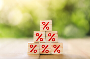 Interest rate financial and mortgage rates concept. Wooden cube block increasing on top with icon percentage symbol upward direction.business concept of investment real estate interest rates appraisal