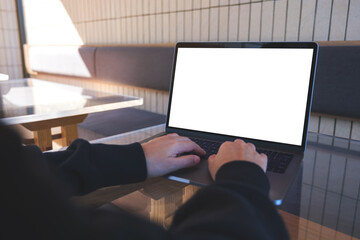 Naklejka premium Mockup image of a woman using and typing on laptop computer with blank white desktop screen