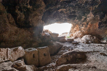 Large  stone millstones are in the cave where the primitive people lived in Tel Yodfat National park, in northern Israel - obrazy, fototapety, plakaty