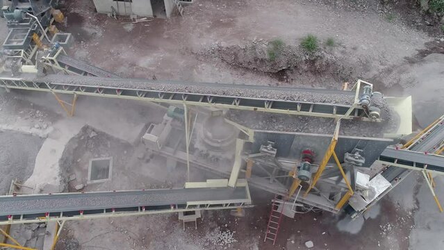 Industrial machine pulverizing rock into different types of gravel and sand in a quarry - Aerial view