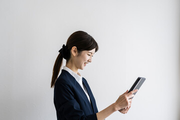 タブレットPCを見るスーツ姿の日本人女性