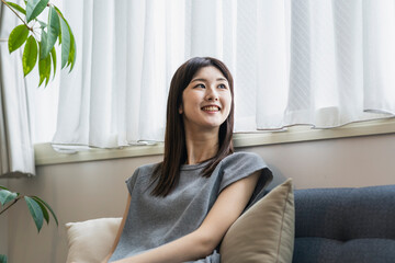 ソファーに座る笑顔の日本人女性