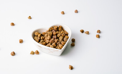 black chickpeas in heart shape bowl with white background