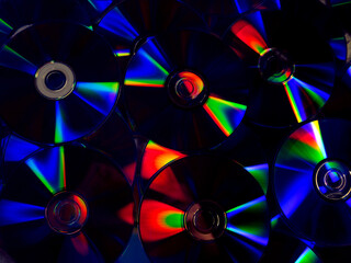 round DVDs with bright multi-colored rainbow highlights on the surface close-up