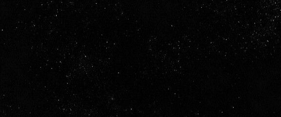 Flying dust particles on a black background, abstract real dust floating over black background for overlay, night sky graphic resources star on snow effect background 
