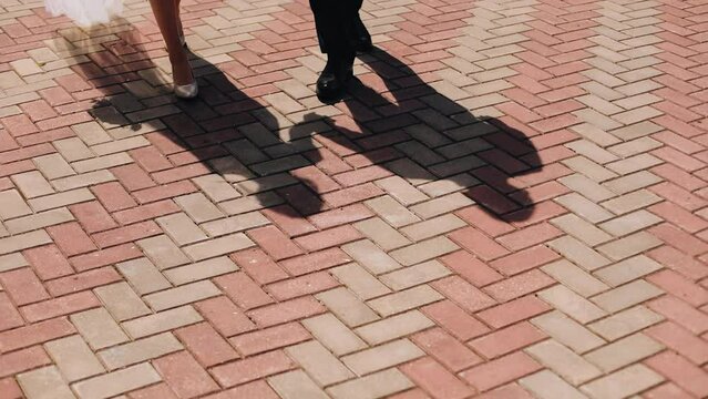 On the ground you can see the shadows of two lovers walking along the road holding hands. Shooting shadows in divzhenie