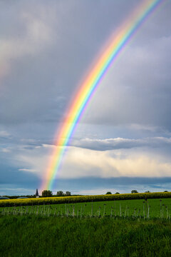 Regenbogen trifft auf Kirche mit Wolken