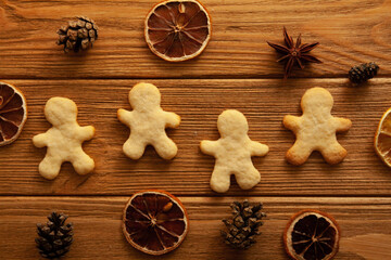 Homemade gingerbread man on wooden background and Christmas decoration