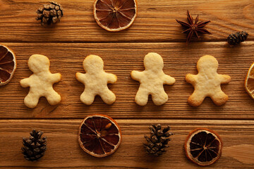 Homemade gingerbread man on wooden background and Christmas decoration