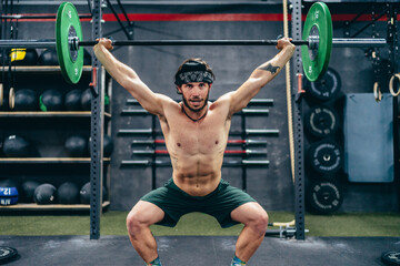 Man doing squat while lifting weight