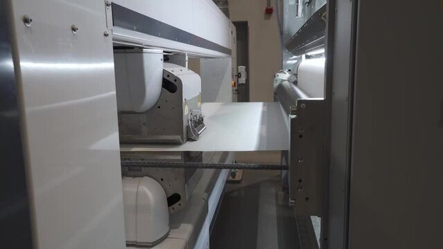 Roller Coating Machine At Work In A Printing Press Industry. closeup, dolly-out shot