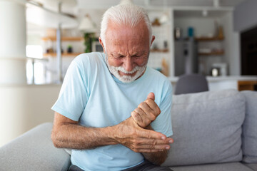 Elderly man has pain in fingers and hands. Old man with finger pain, Man massaging his arthritic...
