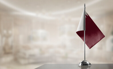 A small Qatar flag on an abstract blurry background