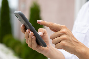 female hands hold a modern mobile phone on the street..education, modern app, shopping order, work online