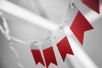 Obraz premium A garland of Malta national flags on an abstract blurred background