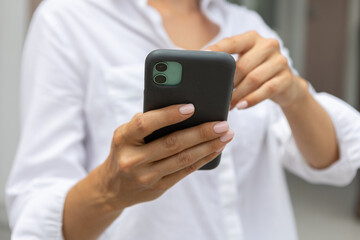 female hands hold a modern mobile phone on the street..education, modern app, shopping order, work online