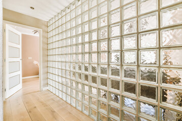 an empty room with lots of glass blocks on the wall and wood flooring in front of the window panes