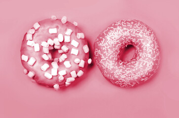 Color of year 2023. Viva Magenta. Two donuts with icing on pastel background. Copyspace