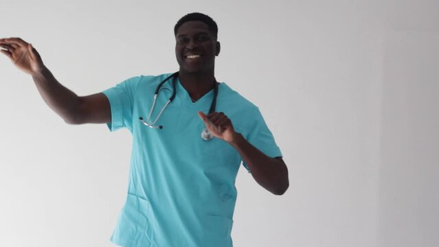 hilarious african american doctor dancing merrily on a white isolated background.