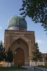 The Bibi-khanum mosque among the greenery against the sky in Samarkand in Uzbekistan. Travel concept.