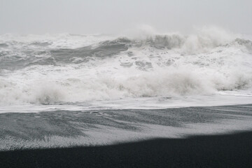 Heavy waves rolling on beach monochrome landscape photo. Beautiful nature scenery photography with sky on background. Idyllic scene. High quality picture for wallpaper, travel blog, magazine, article