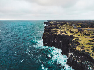 Majestic volcanic coast of West Iceland with cliffs and rough sea