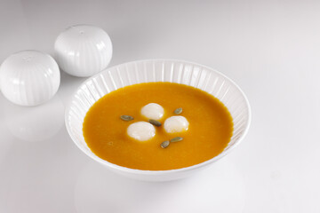 Hobakjuk, Korean pumpkin porridge with rice balls, topping with pumpkin seed.