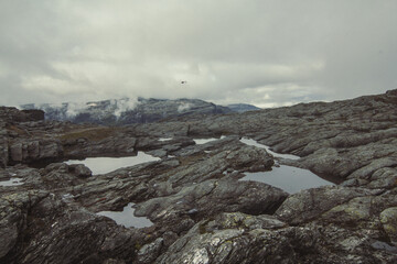 Puddles on rocky hill landscape photo. Beautiful nature scenery photography with overcast sky on background. Idyllic scene. High quality picture for wallpaper, travel blog, magazine, article