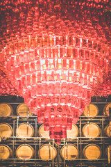 Close up wonderful luster hanging in wine cellar concept photo. First view person photography with wooden barrels on background. High quality picture for wallpaper, travel blog, magazine, article
