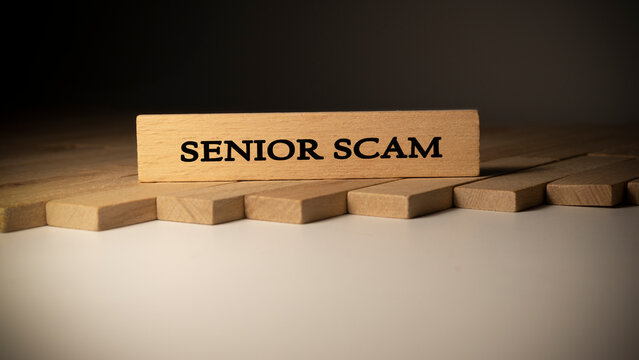Senior scam word. Background log written on wooden frame.
