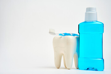A toothbrush with toothpaste and mouthwash on white background