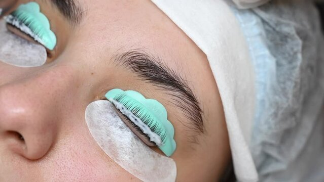 Close-up portrait of a woman on eyelash lamination procedure. 