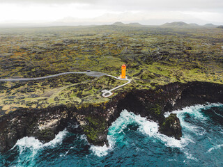 Aerial view of orange Svortuloft Lighthouse by the sea in West Iceland highlands, Snaefellsnes...