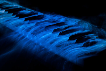 white keyboard piano covered by blue light © Lukasz