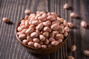 raw peanuts or groundnut on wooden table.