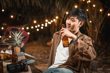 young Asian males holding beer bottle enjoy the night party