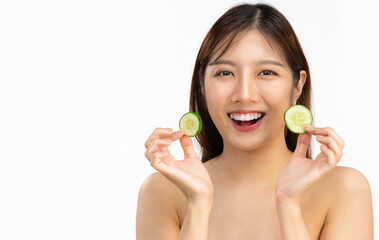 Young asian woman natural and fresh skin face using cucumber slices for spa treatment and skin care white background.