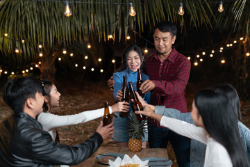 Young couples and friends enjoy a happy holiday party drinking beer together.