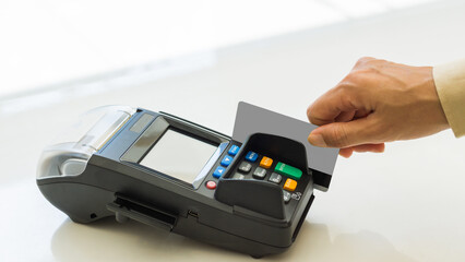 Closeup moment of payment with a credit card machine. Cashless paying for shopping concept. Buy and sell products & service concept