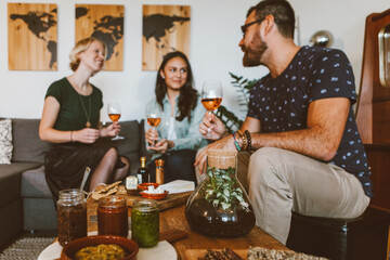 friends meeting at home with a glass of wine and appetizer