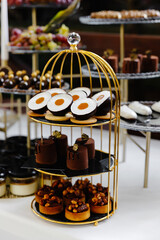 Many cakes standing among the candy bar. Sweet table. Banquet table. Holiday food and sweet festive table.