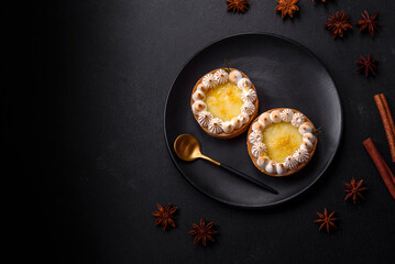 Delicious fruity sweet tart with lemon flavor and cream on a black plate