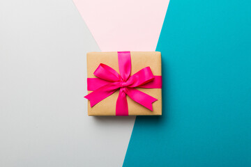 holiday paper present tied pink ribbon bow top view with copy space. Flat lay holiday background. Birthday or christmas present. Christmas gift box concept with copy space