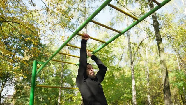A strong sports man works out on parallel bars