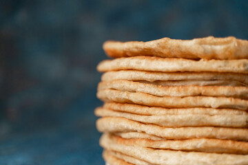 Flatbread lavash, chapati, naan, heap of tortilla on a blue background Homemade flatbread stacked.