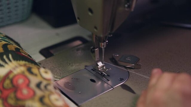 Young woman threading her sewing machine